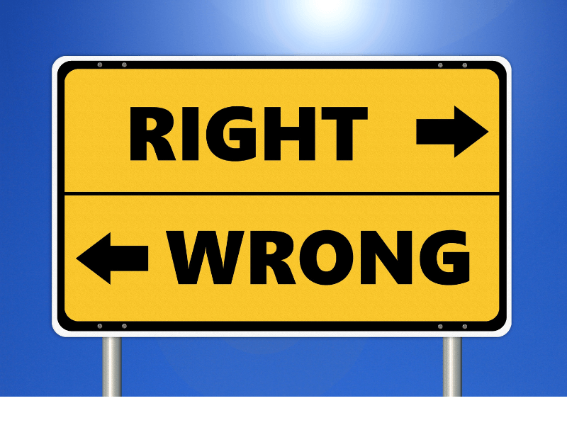 A road sign that reads "right" and "wrong" with arrows pointing in different directions. The sign is yellow and the background is blue.